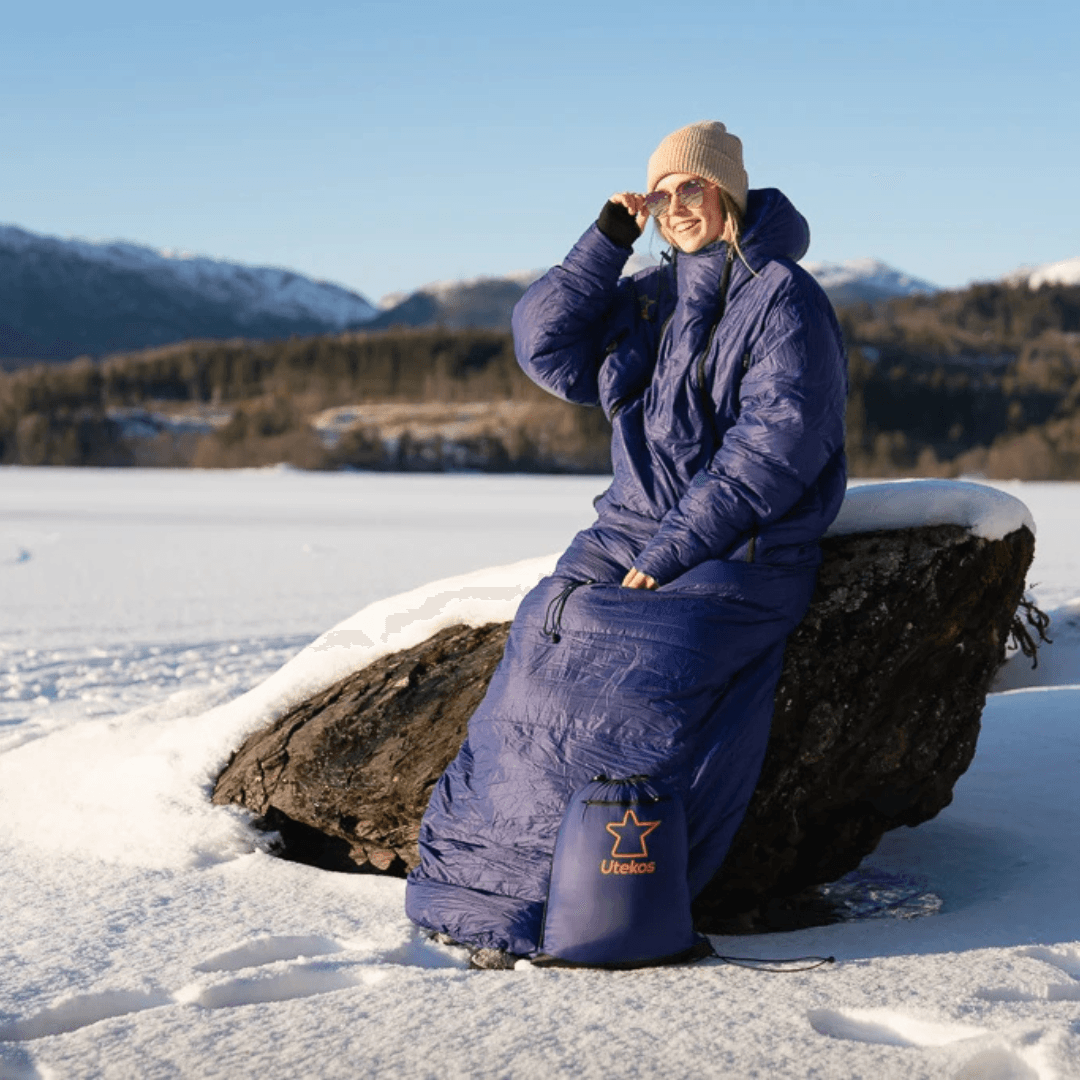 To personer i Utekos-plagg nyter utsikten fra en fjelltopp.