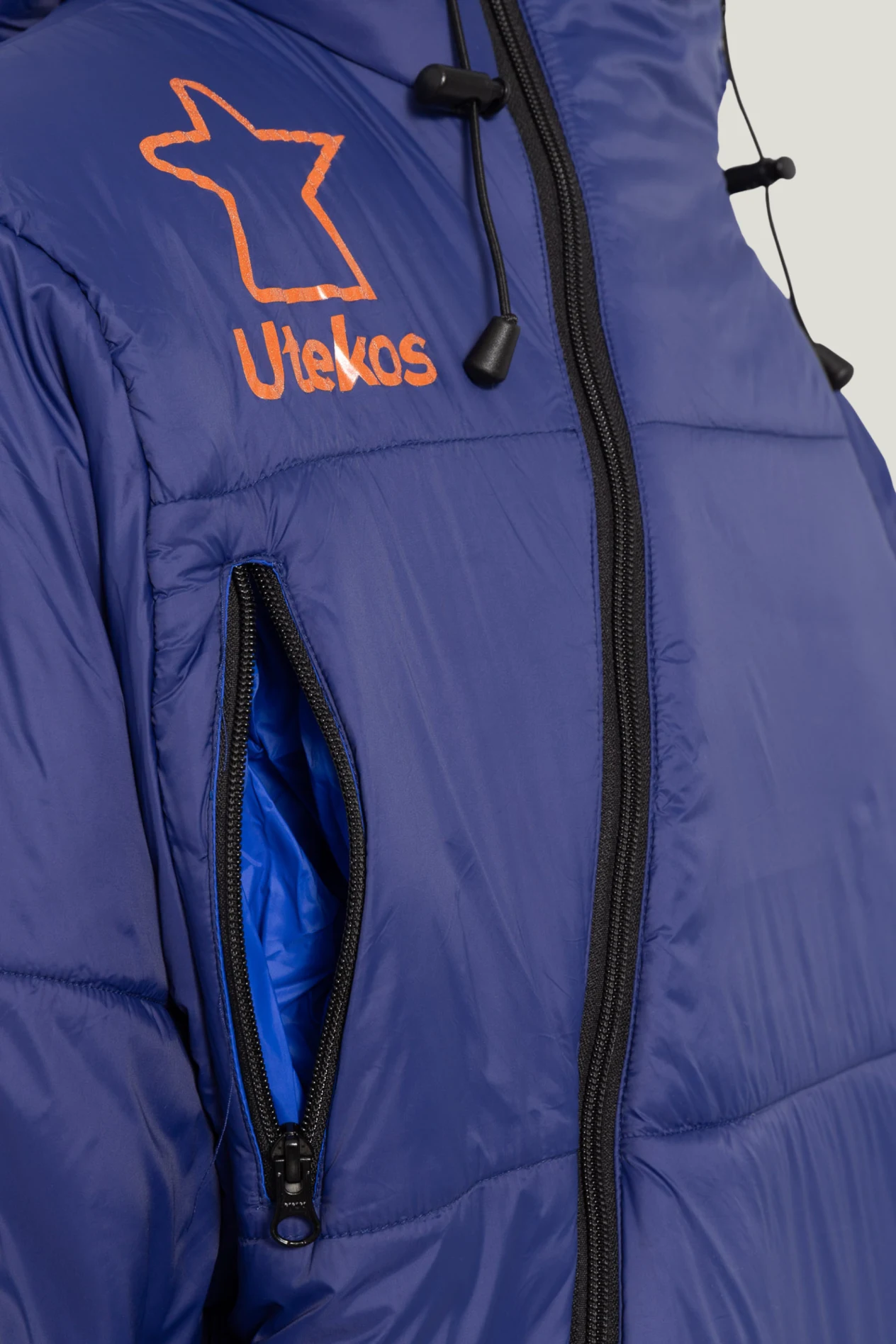 Nærbilde av lomme og glidelås på fjellblå Utekos Mikrofiber.