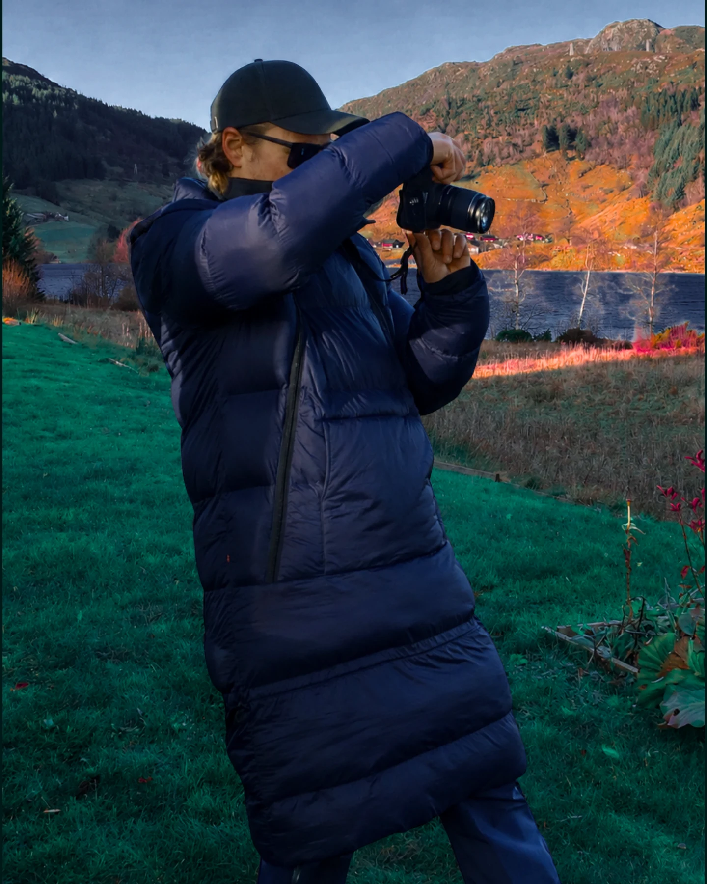 Person i Utekos TechDown fotograferer ved et fjellvann.