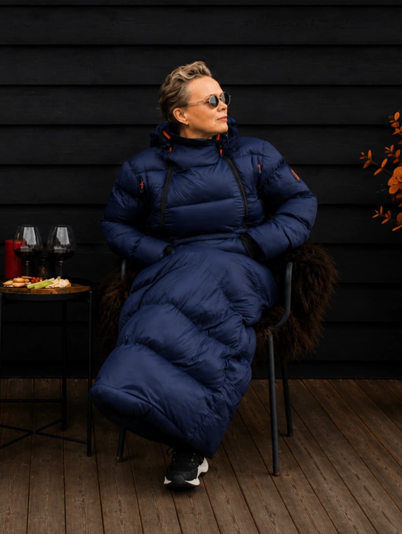 Person som sitter på en terrasse i mørkeblå Utekos TechDown™.