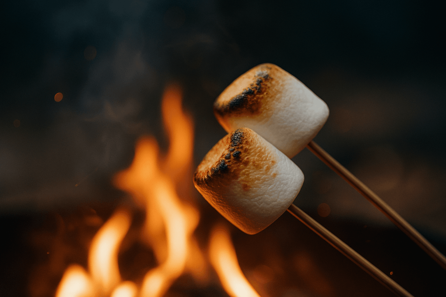 Nærbilde av en marshmallow som grilles til perfeksjon over glørne i en bålpanne.