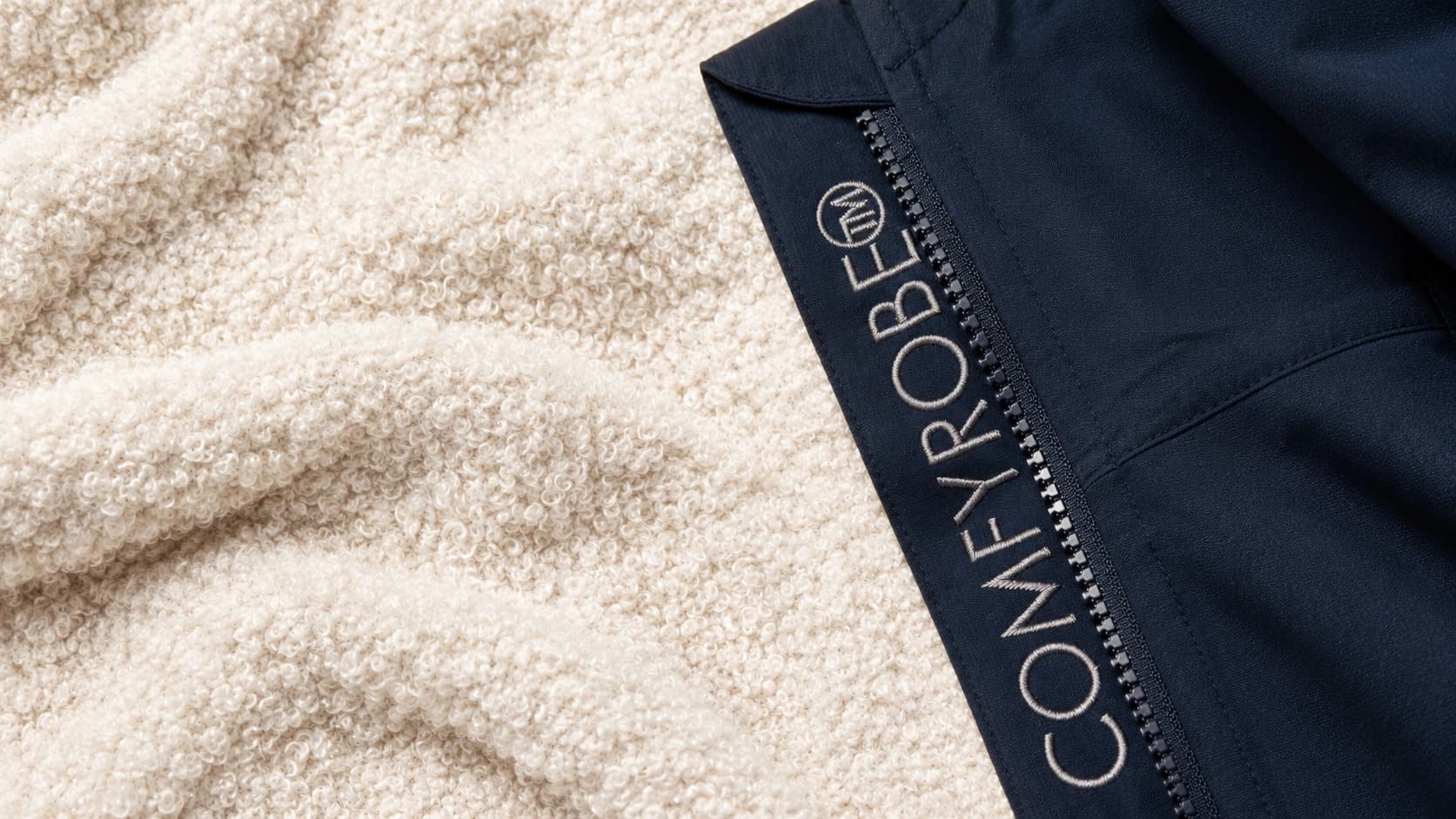 Makrofotografi av hvit og gråtonet sherpa-fleece i 100 prosent polyester som viser den krusede, hevede tekstilstrukturen i naturlig nordisk dagslys.