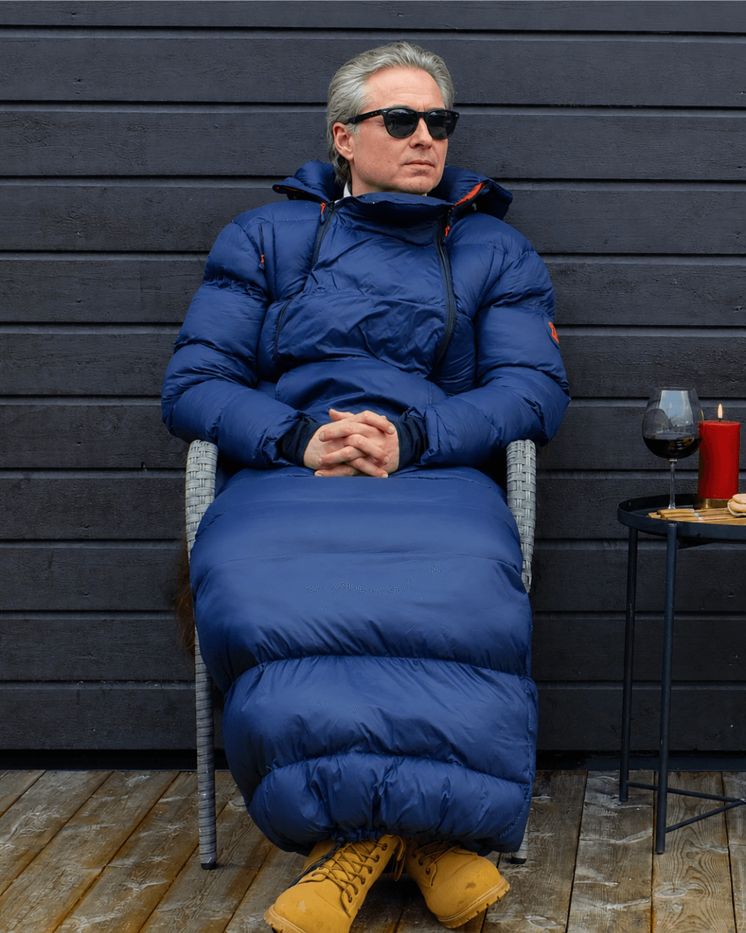 Mann med Utekos TechDown og solbriller slapper av på terrassen.